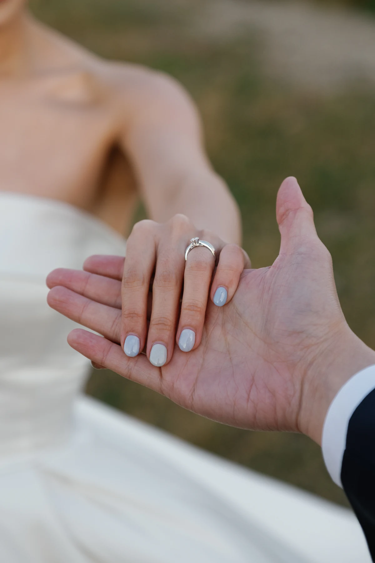 The bride's ringed hand gently holding the groom's hand